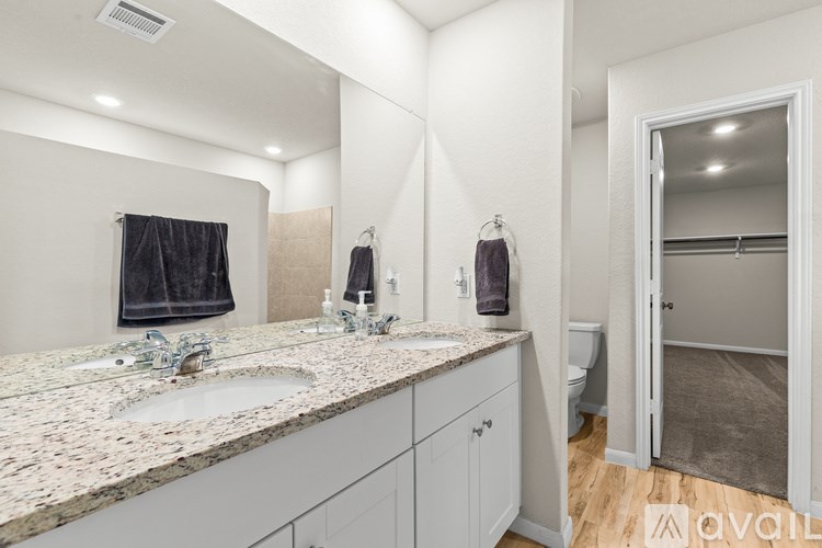 A bathroom with a granite countertop and a large mirror.