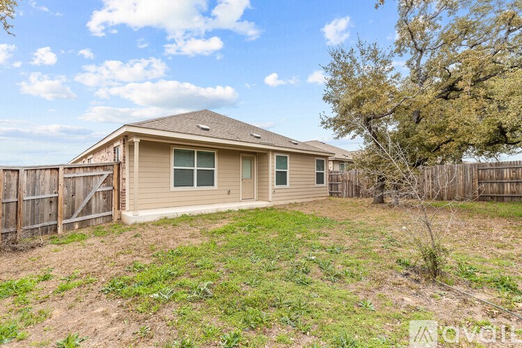 A house with a brown roof and a fence in front of it.