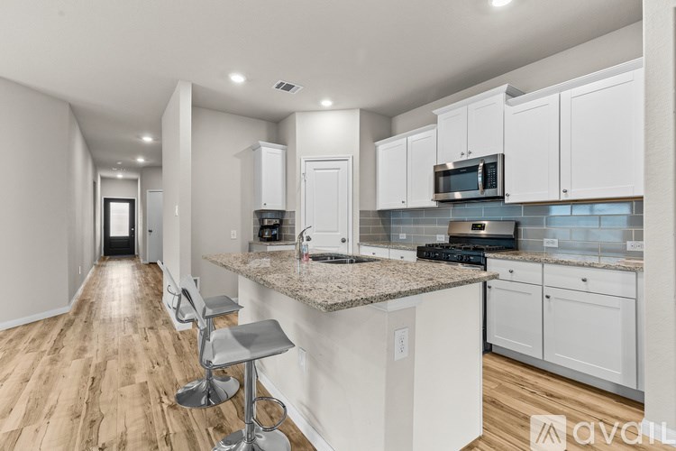 A kitchen with white cabinets and a granite countertop.