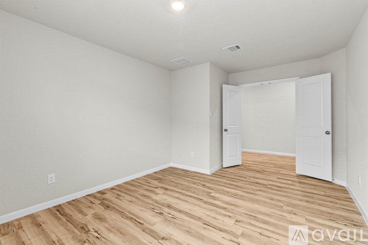 A room with wooden flooring and white walls.