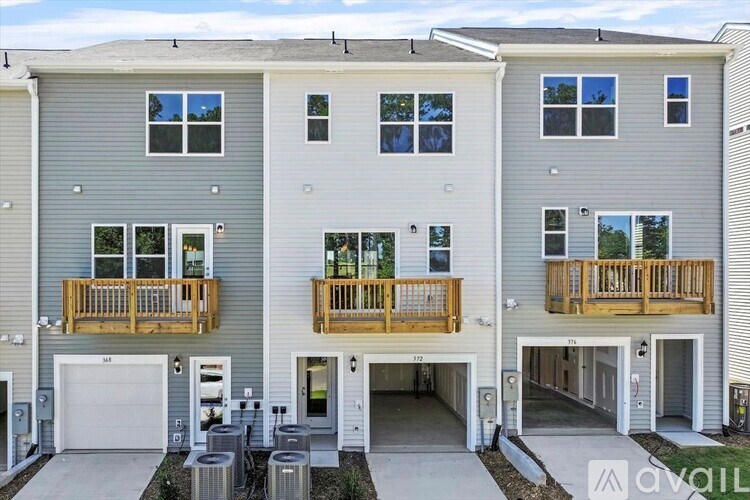 A modern two-story building with a garage and balconies.