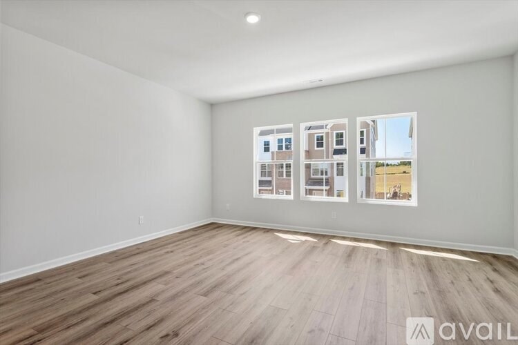 A room with wooden flooring and a wall with pictures of houses.