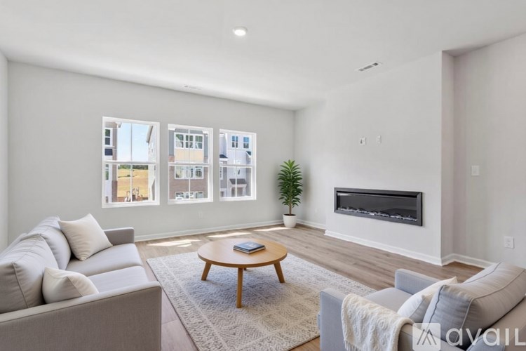 A living room with a grey couch, a wooden coffee table, and a fireplace.