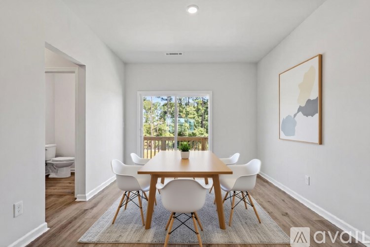 A dining room with a wooden table and white chairs.