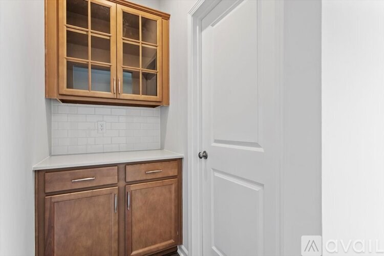 A kitchen with wooden cabinets and a white door.