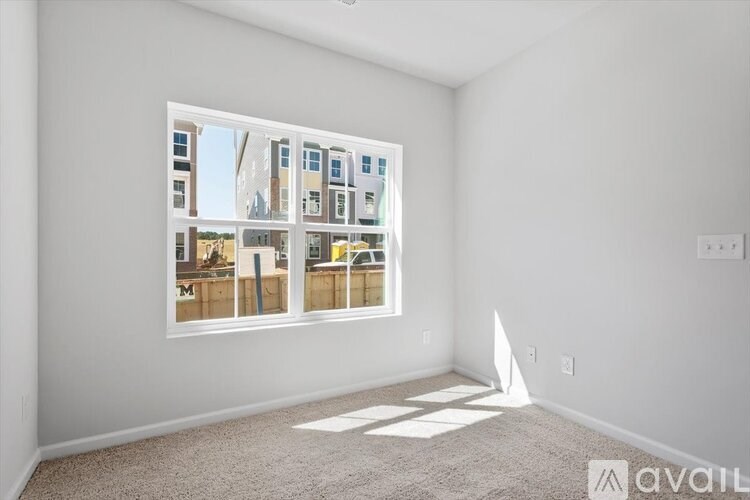 A room with a large window showing a view of buildings outside.
