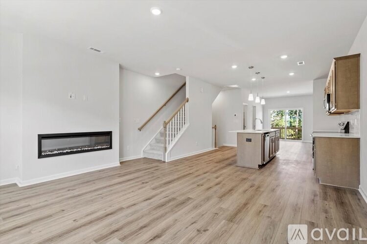 A spacious living room with a fireplace and wooden flooring.