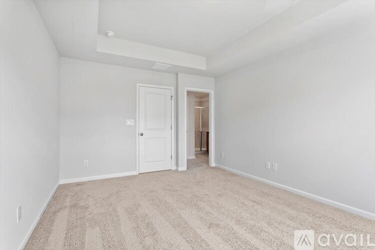 A room with a carpeted floor and a doorway leading to another room.