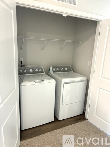 Two white front loading washing machines in a small laundry room.