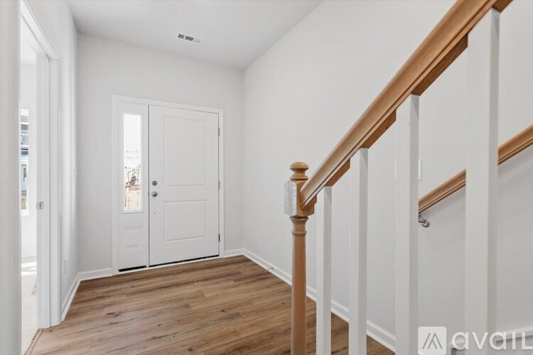 A hallway with a wooden staircase and white walls.