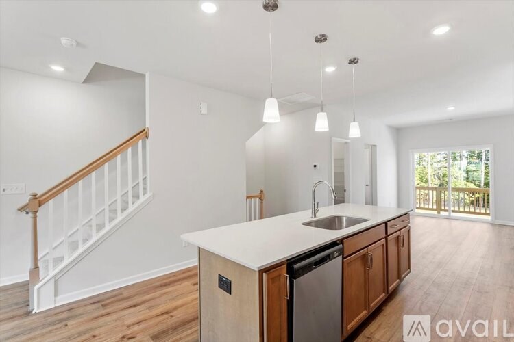 A kitchen with a white countertop and wooden cabinets.