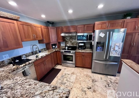 A kitchen with wooden cabinets and granite countertops.