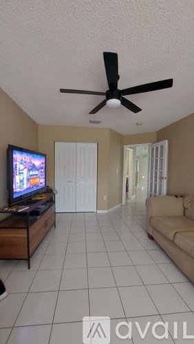A living room with a television and a couch.