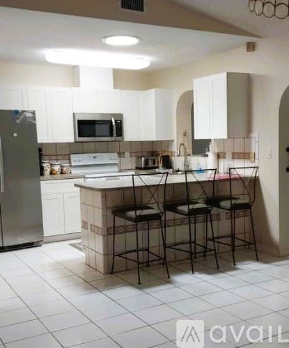 A kitchen with white cabinets and a white counter top.