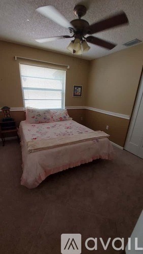 A bedroom with a bed and a ceiling fan.