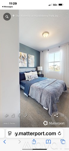A bedroom with a bed covered in a blue comforter.