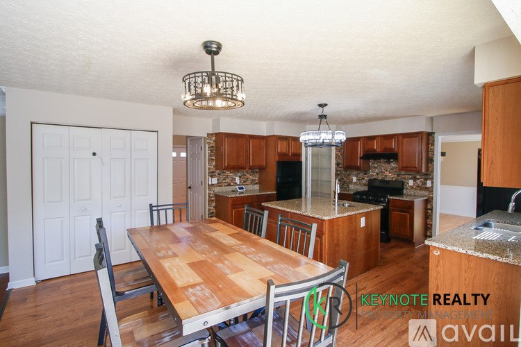 A kitchen with wooden cabinets and a dining table.