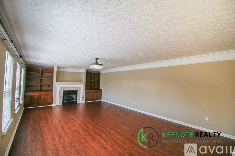 A room with a fireplace and wooden floors is available for rent.