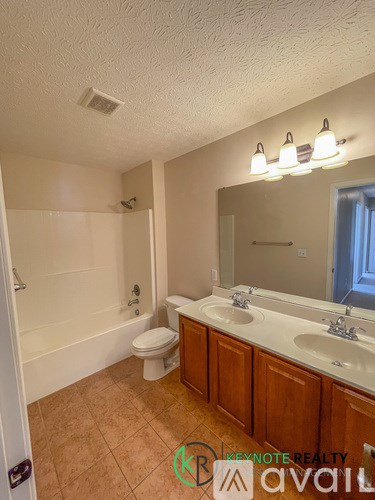A bathroom with a toilet, sink, and bathtub.