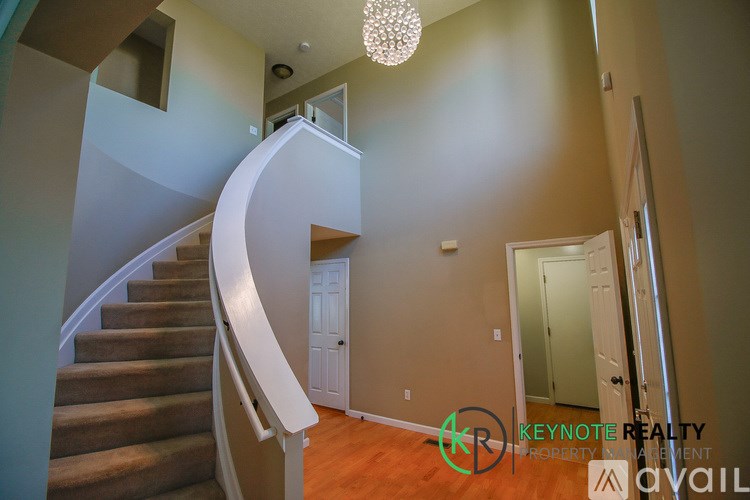 A staircase with a chandelier in the middle of the room.