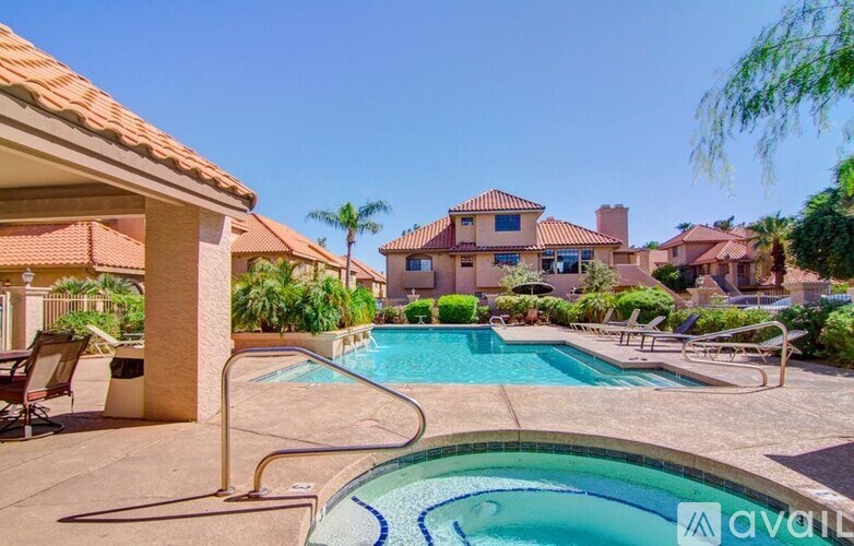 A pool with a slide and a house in the background.