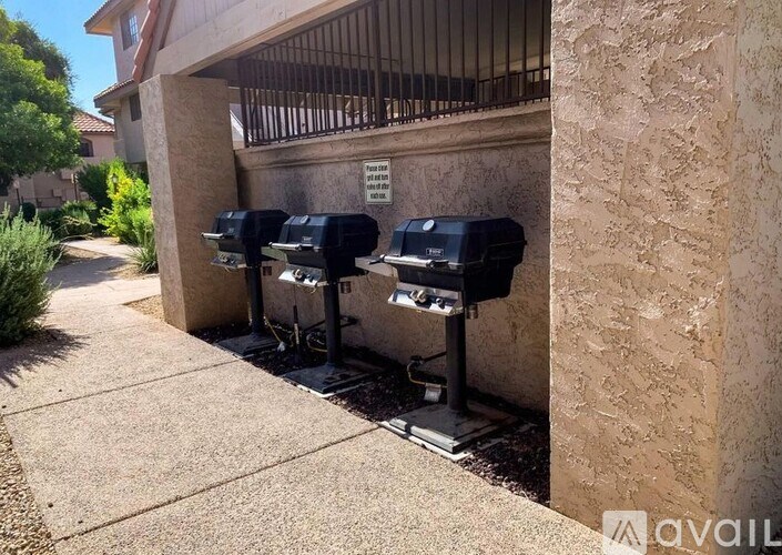 A row of mailboxes are on the sidewalk outside a building.
