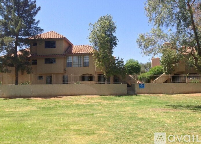 A house with a red roof and a green lawn in front.
