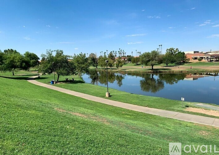 A park with a pond, trees, and a walking path.