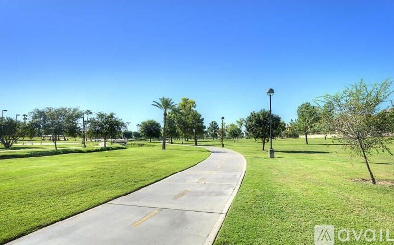 A park with a walking path and trees.