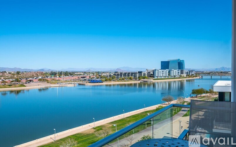 A view of a waterfront with a building in the distance and a clear blue sky.
