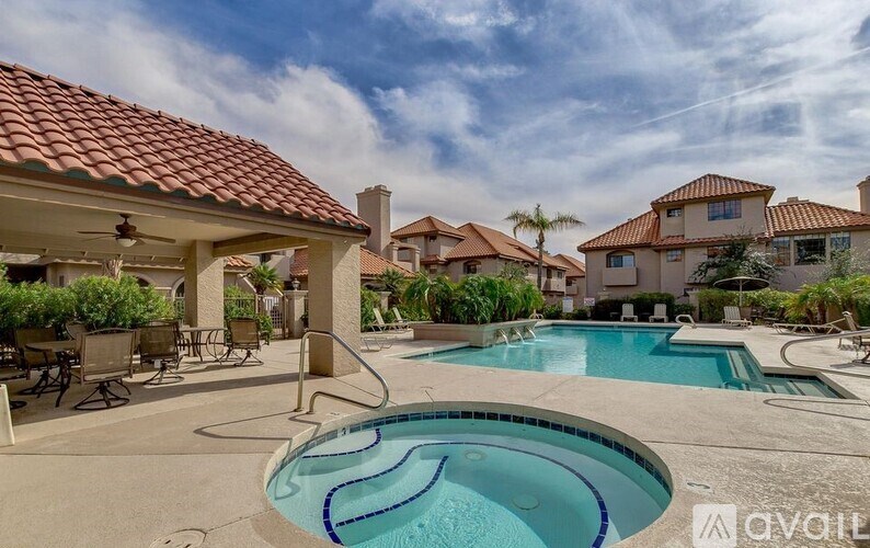 A swimming pool in a backyard with a patio and a house in the background.