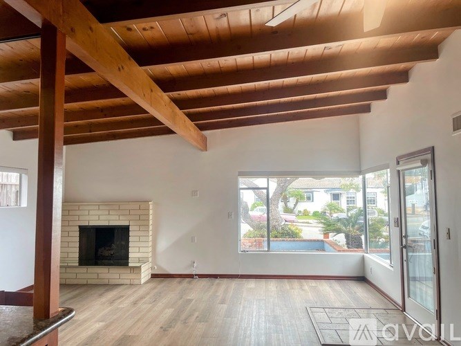 A living room with a fireplace and a view of the backyard.