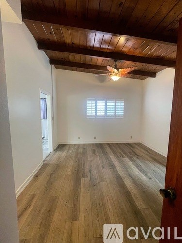 A room with wooden floors and a ceiling fan.