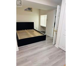 A bedroom with a black bed and a white door.