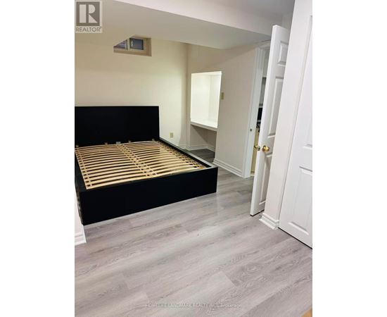 A bedroom with a black bed and a white door.