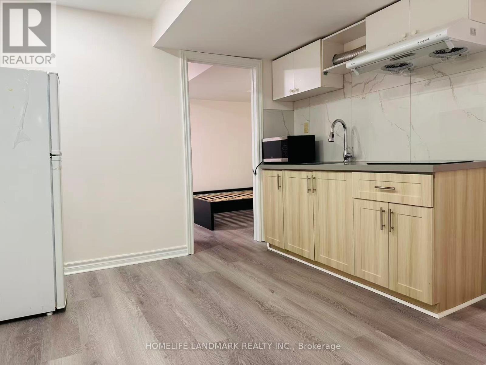 A kitchen with wooden cabinets and a white refrigerator.
