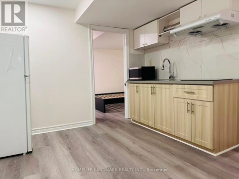 A kitchen with wooden cabinets and a white refrigerator.