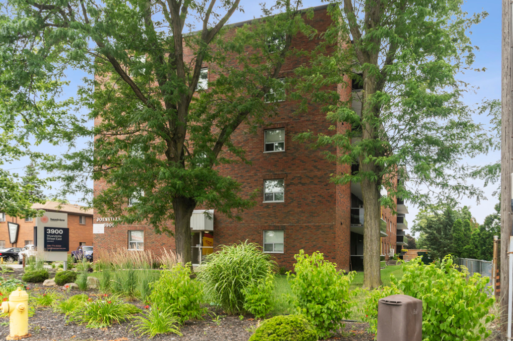 A brick building with a tree in front of it.