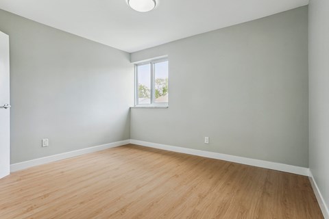 Empty room with wooden floor and a window.