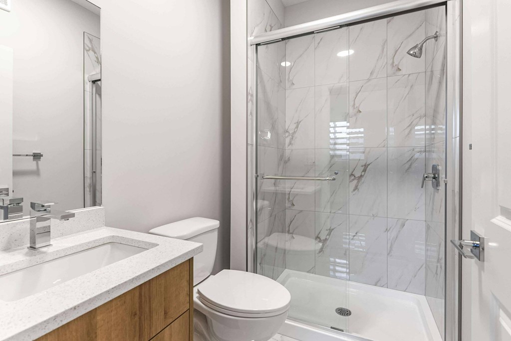 A white toilet sits next to a sink in a bathroom.