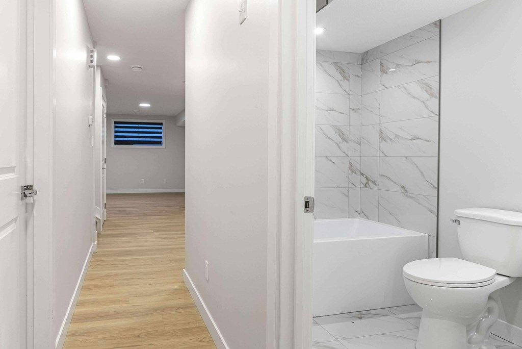 A white bathroom with a toilet, sink, and bathtub.