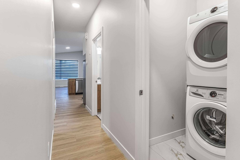 A white washing machine is in a small laundry room.