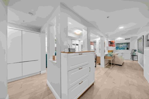 A kitchen with white cabinets and a wooden countertop.