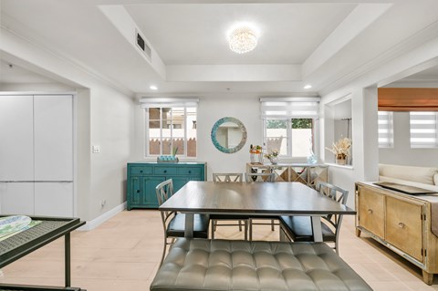 A modern dining room with a dark table and chairs.