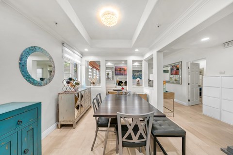 A dining room with a table and chairs.