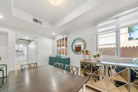 A modern living room with a wooden floor and a large mirror on the wall.