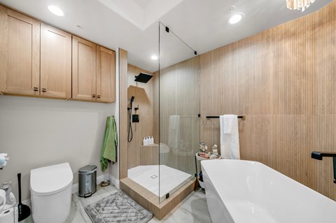 A modern bathroom with a walk-in shower and a white bathtub.