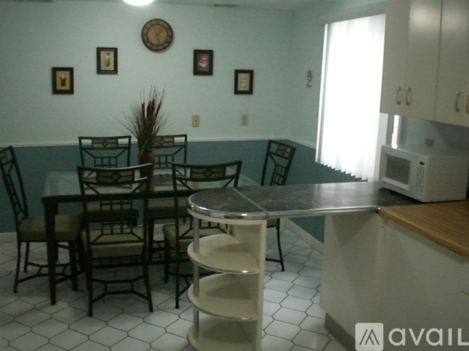 A kitchen with a table and chairs.