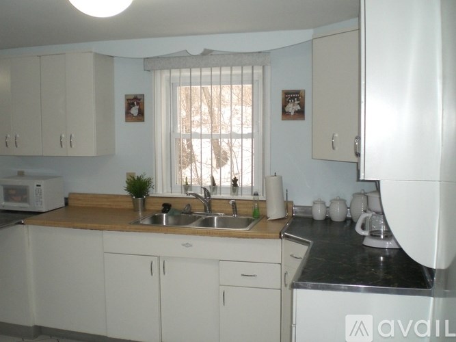A kitchen with white cabinets and a wooden countertop.