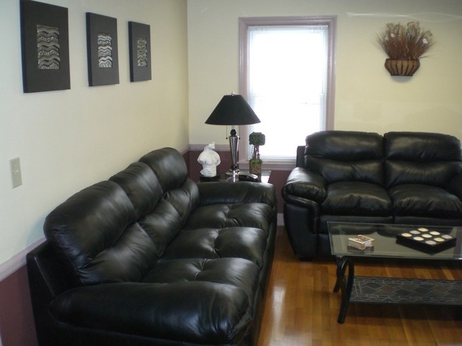 A black leather couch and chair in a room.